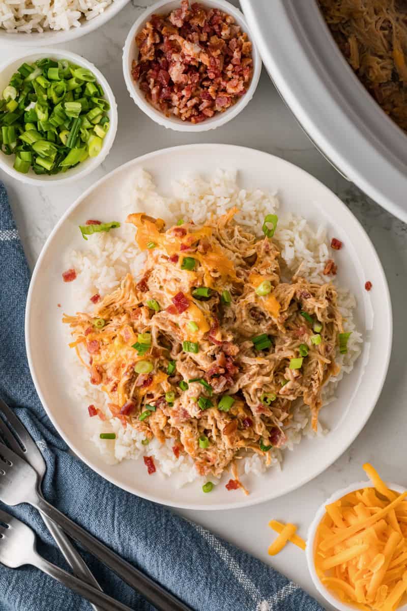 top-down view of the Crack Chicken served on a bed of rice on a white plate.