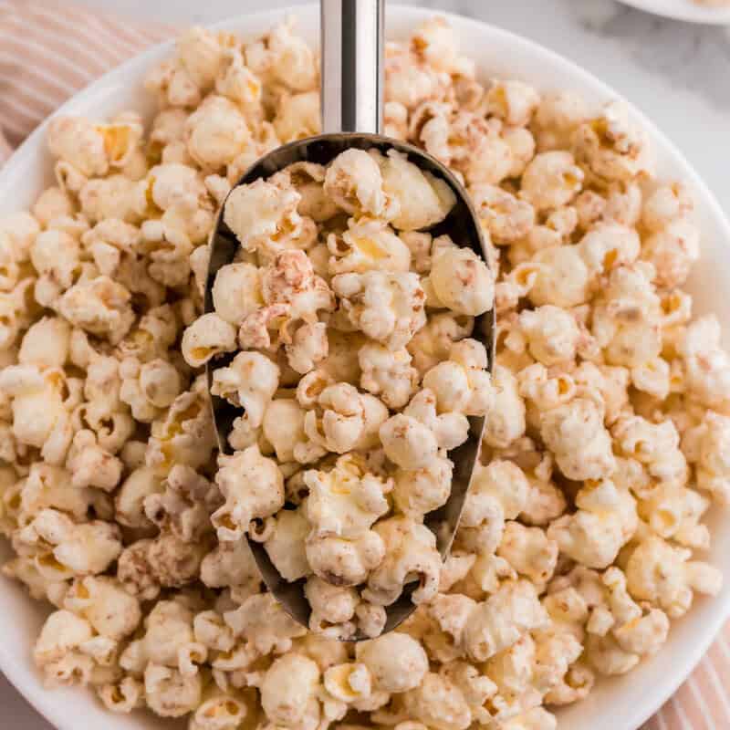 serving the Pumpkin Spice Popcorn with a metal scoop.