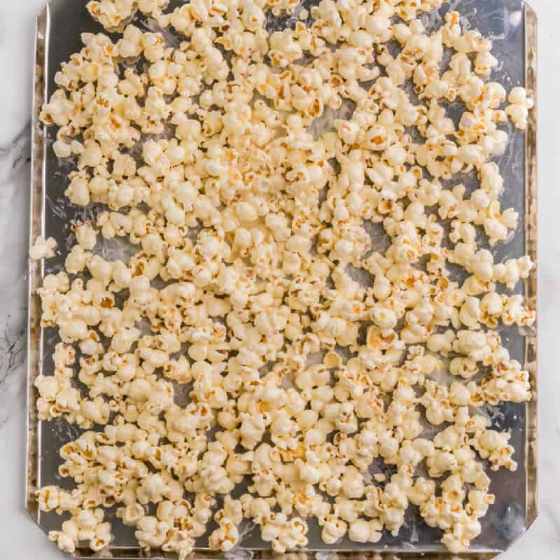 popcorn spread out on the baking sheet.
