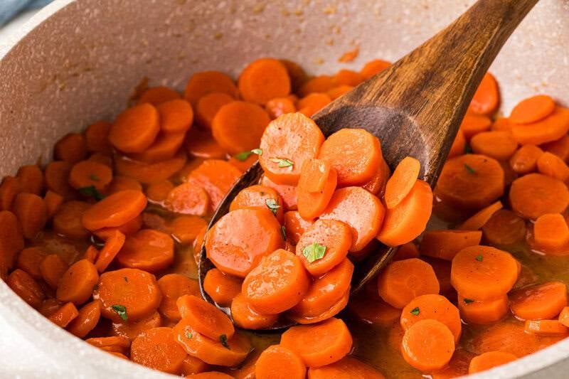 serving the carrots out of the pot.
