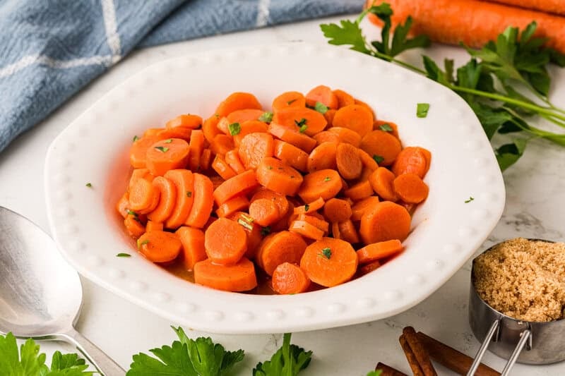 serving the carrots in a white bowl.