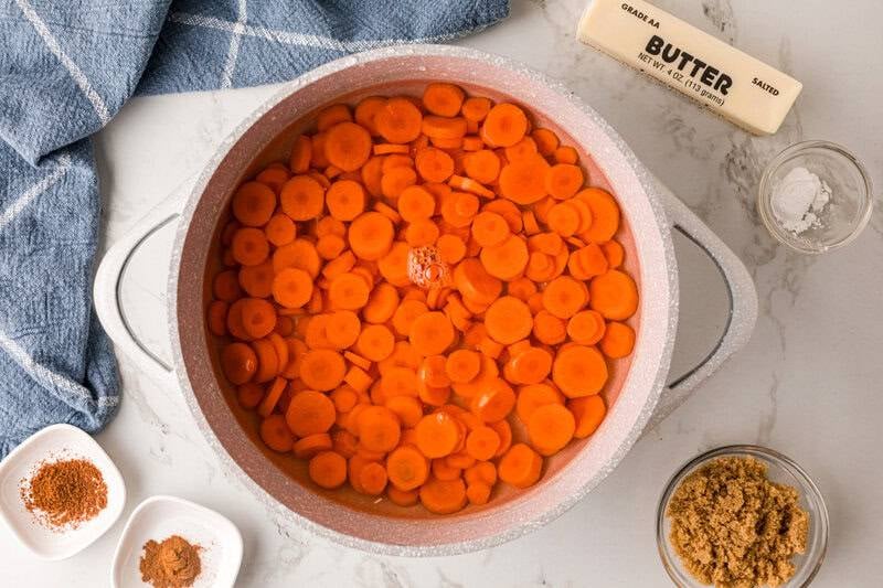 cooking the carrots in a large pot.