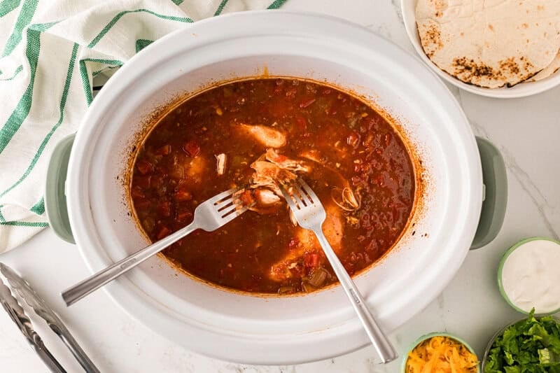 shredding the chicken in the slow cooker.