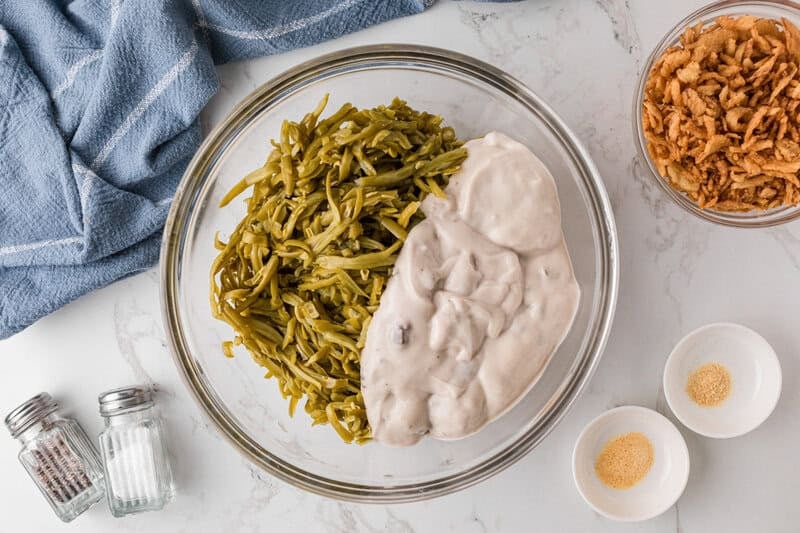 mixing together the green beans and the mushroom soup.