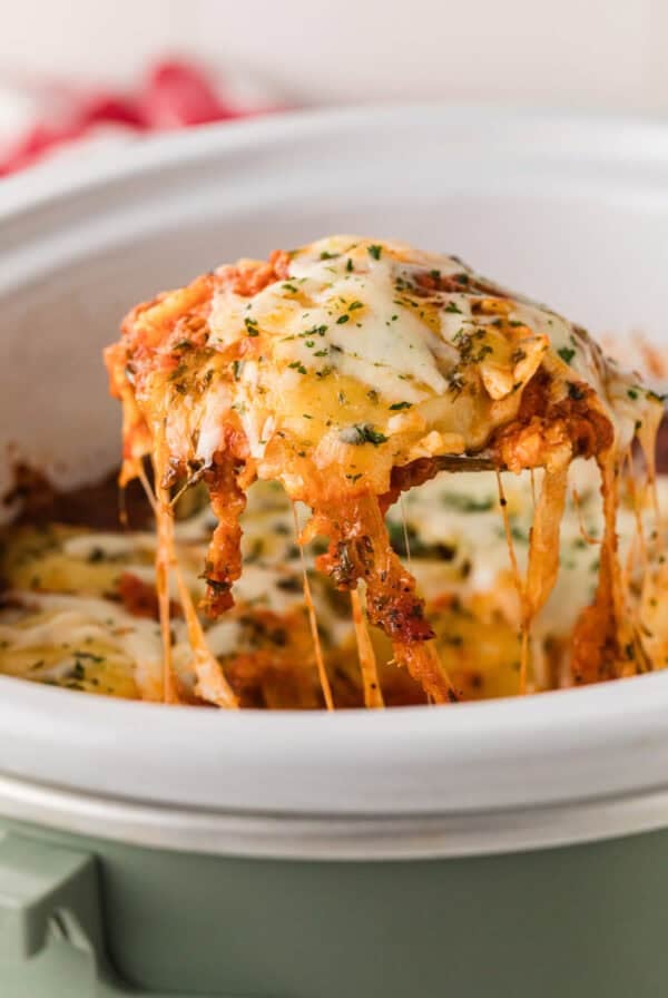 Slow Cooker Ravioli Lasagna (Lazy Lasagna) being spooned out of the crockpot