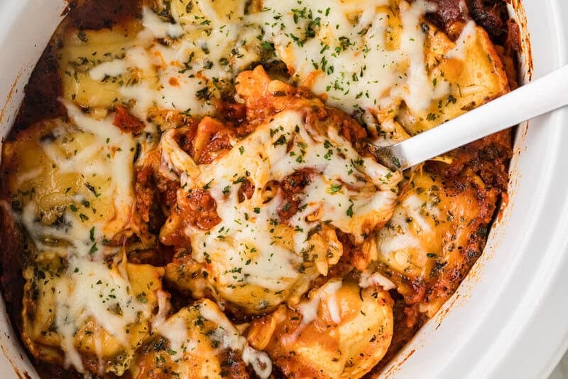 serving the Slow Cooker Ravioli Lasagna out of the slow cooker.